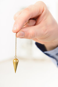 Dowsing for Health. Dowsing hand with pendulum